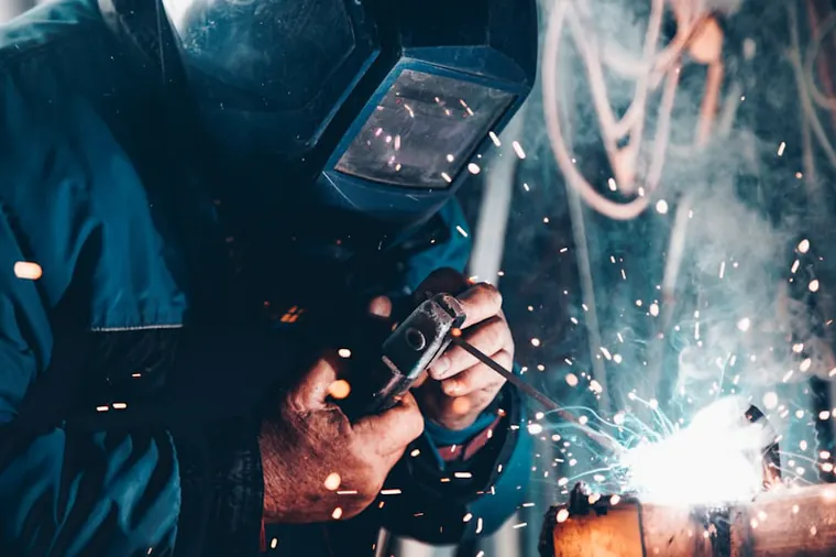 Soldador fabricando estructura metálica en taller de metalmecánica